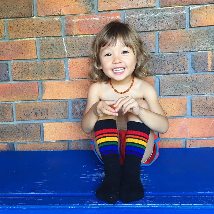 Close-up of black Brave rainbow baby socks with colorful stripes while hanging out
