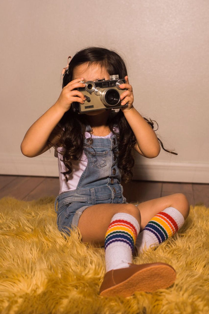 Fearless  rainbow Baby/Toddler Tube Socks by Pride Socks while taking photos sitting on the carpet